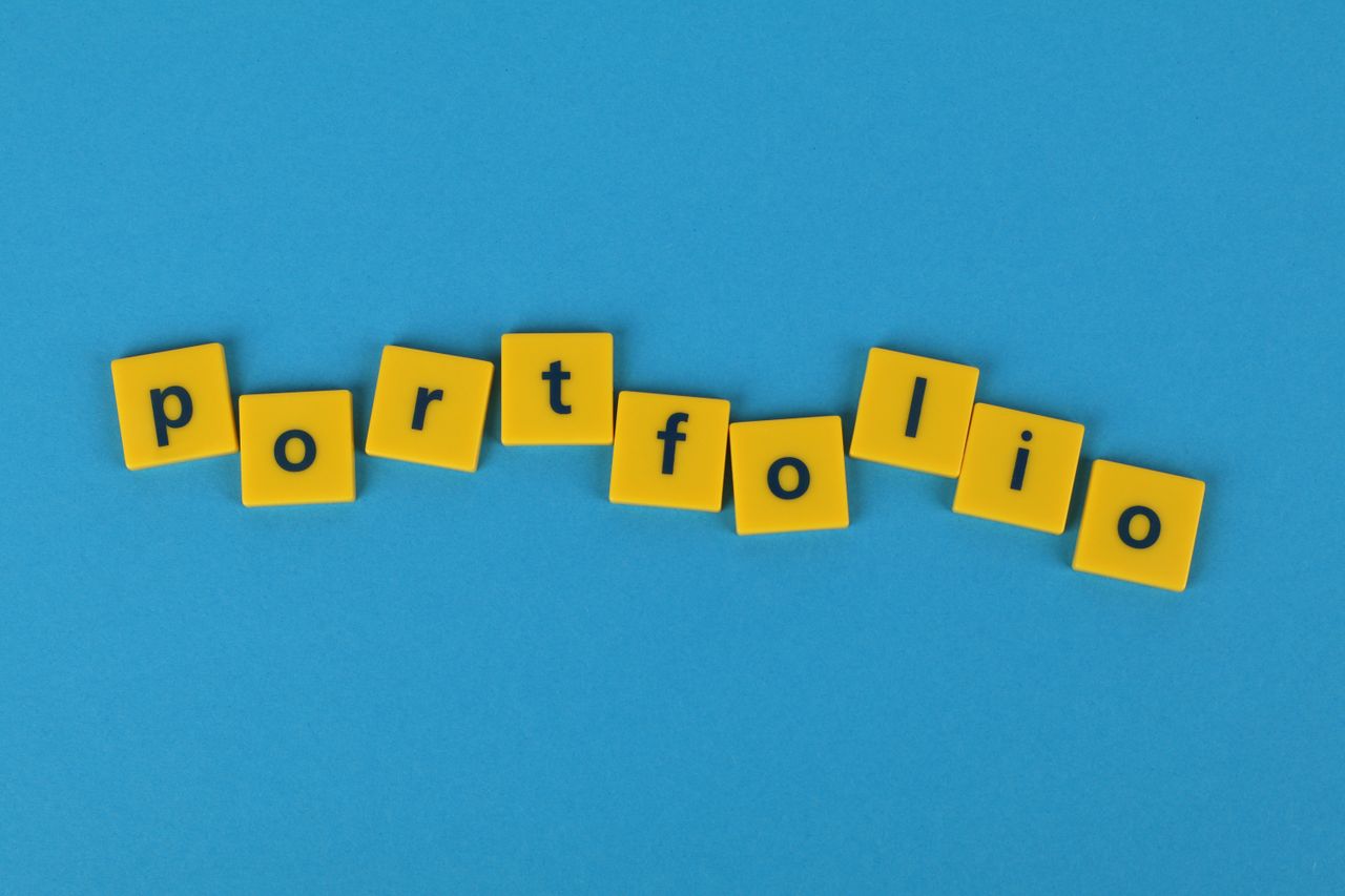 Des lettres de Scrabble jaunes sur un fond bleu formant le mot « portfolio ». Idéal pour des thèmes liés aux affaires.